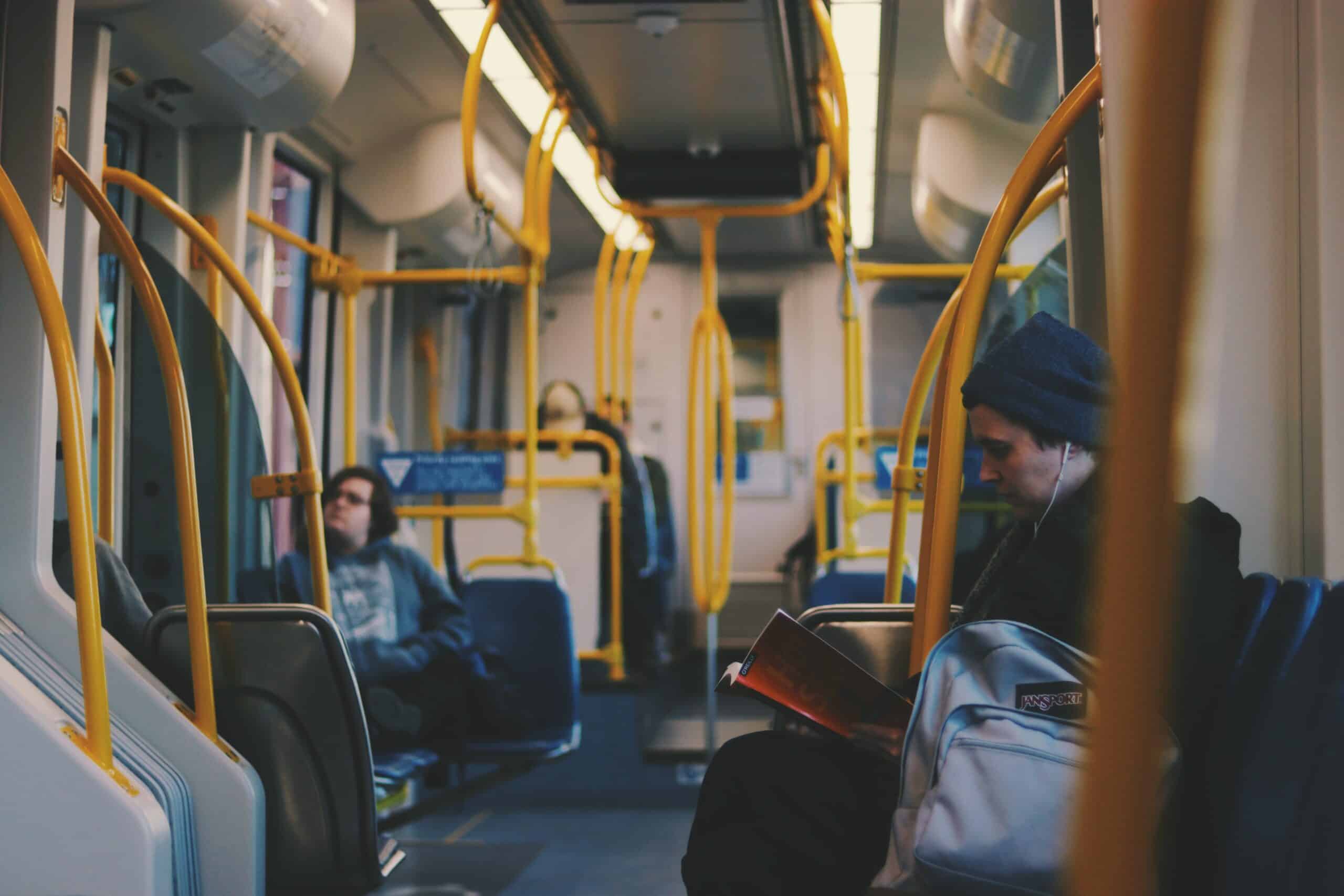 a man reading a book on a public bus