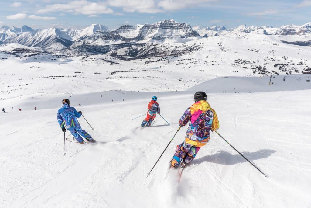 Three people skiing.