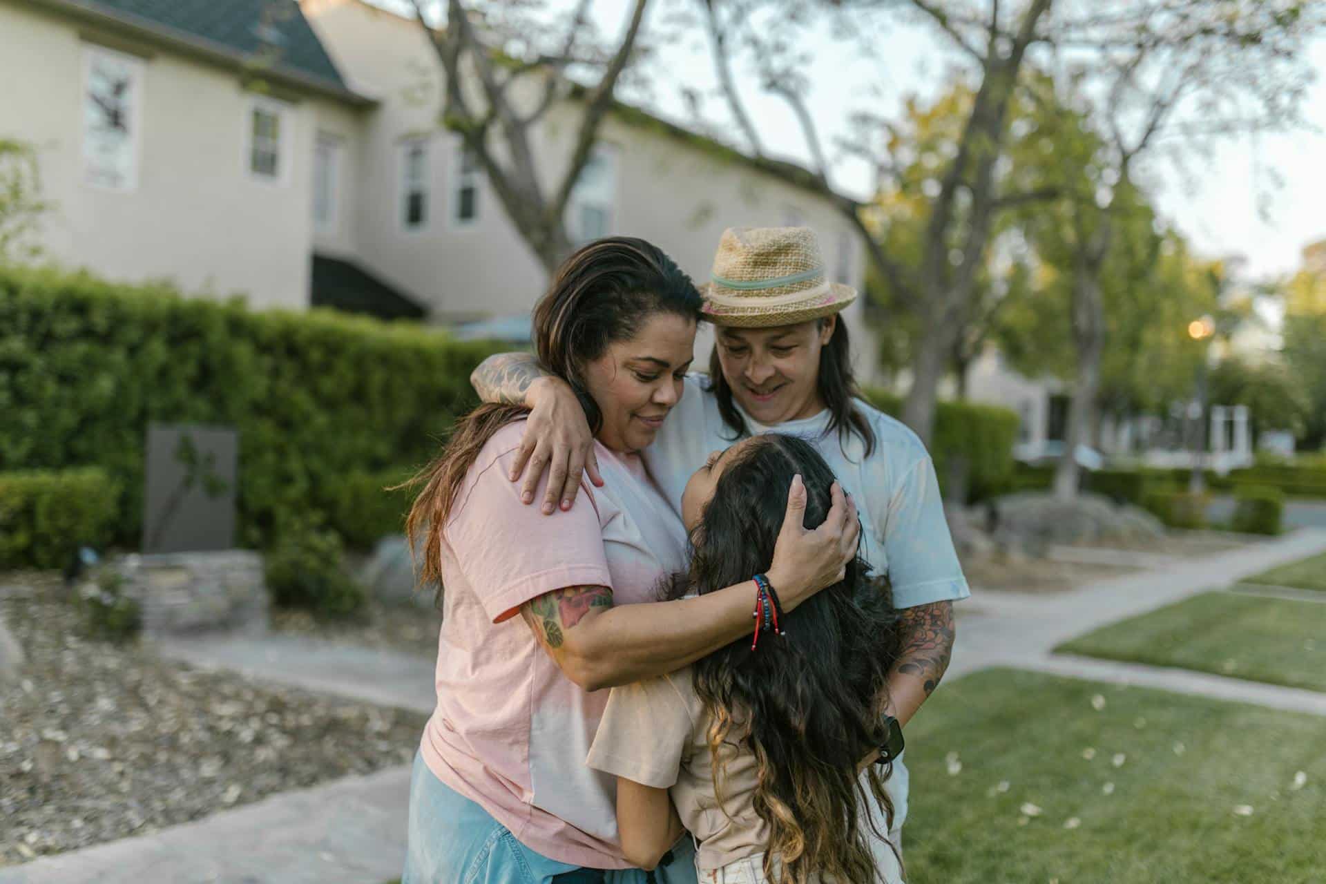 Loving family embracing outdoors in a quiet suburban neighborhood, symbolizing connection and warmth in a new community.