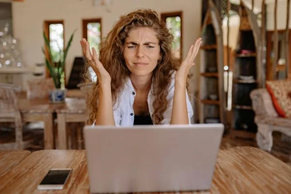 Frustrated expat dealing with international movers’ hidden fees on a laptop