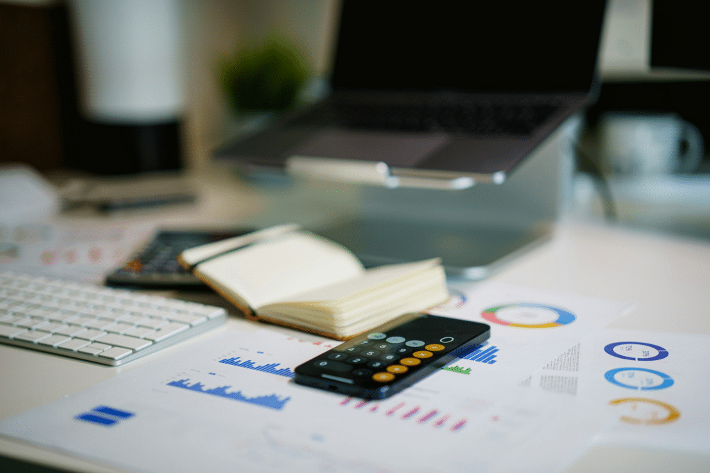  Financial planning papers, a calculator, and a laptop laid out on a desk
