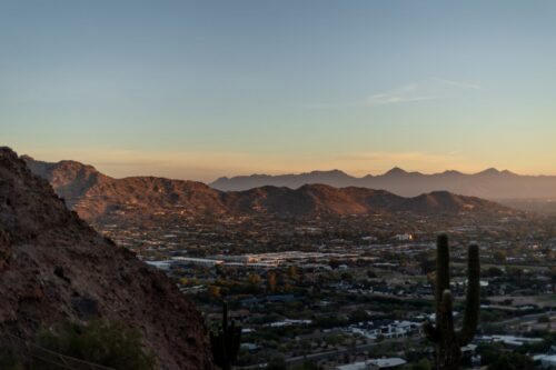 a view of Phoenix cityscape and desert mountains at sunset